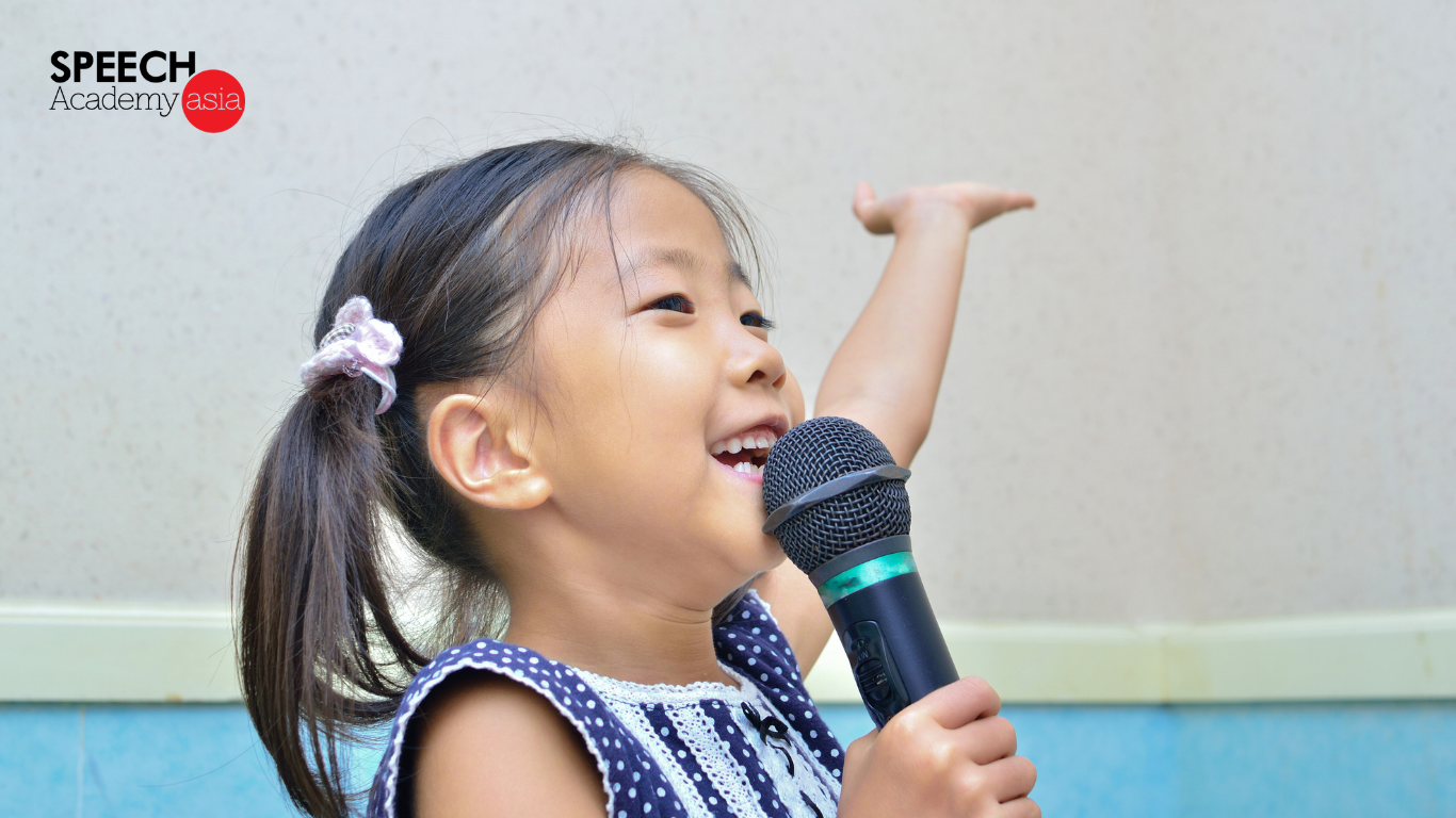 Young girl confidently speaking into a microphone during public speaking practice