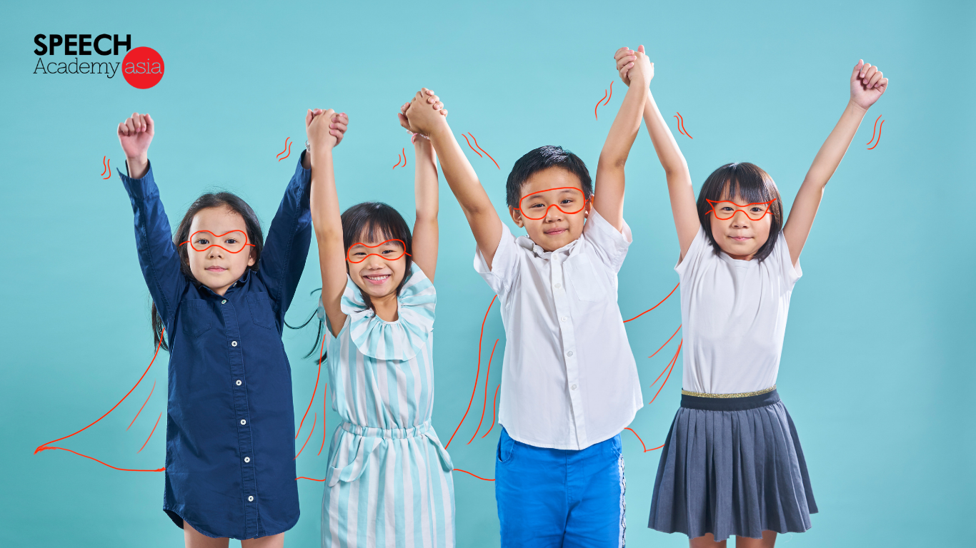 Four children raising their hands confidently with doodle capes drawn on them, symbolising young leaders in a leadership programme for kids in Singapore.